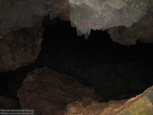 Stalctites dipping to the pool of water