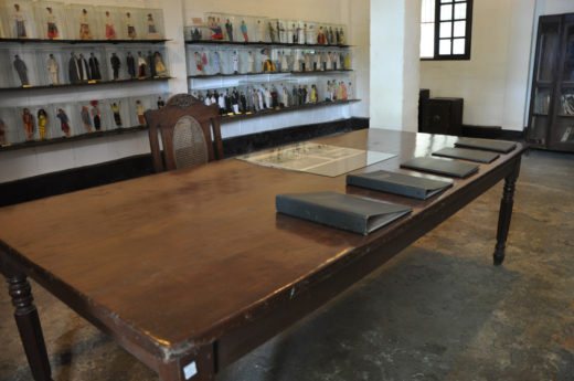 Big table surrounded with dolls